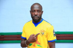 e-readmedia-Benjamin-Ochan-points-to-the-KCCA-badge